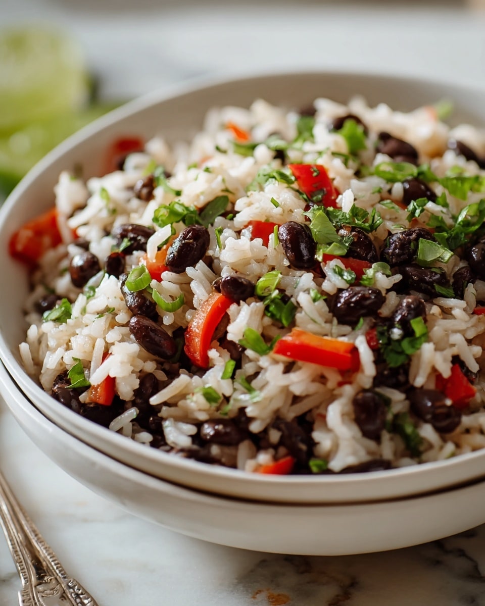Large white bowl filled with a vibrant, whole serving of seasoned rice and black beans mixed with diced tomatoes, finely chopped onions, fresh green herbs, and slices of green chili peppers, showcasing the colorful ingredients and inviting textures, photographed from a 3/4 angle on a white marble countertop with natural lighting, styled like a premium food magazine hero shot, photo taken with an iphone --ar 4:5 --v 7